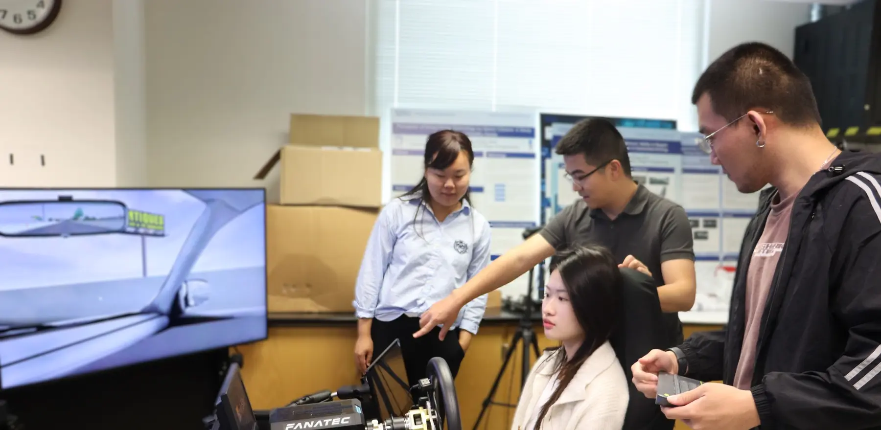 BAT Lab members gathered around the driving simulator during a research session.